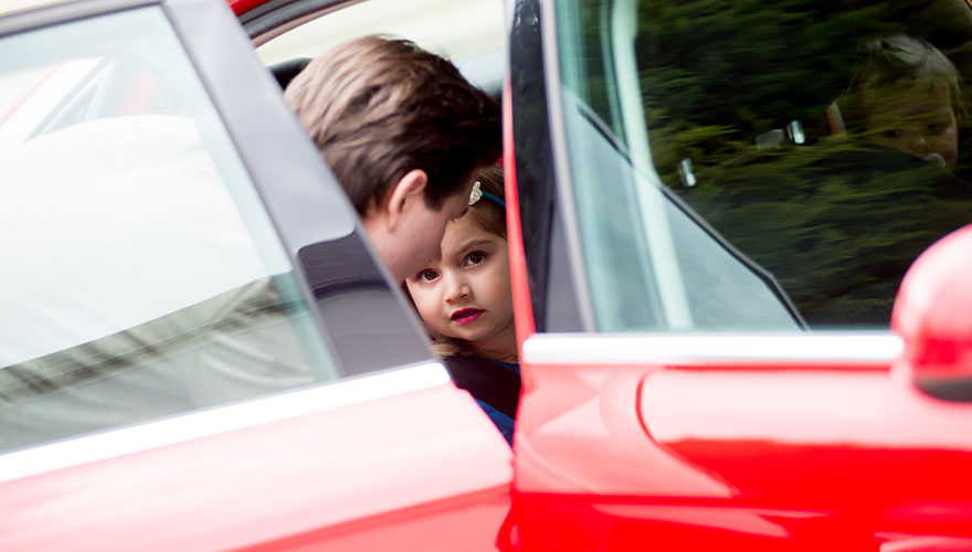 Ein Bräutigam hilft seiner kleinen Tochter beim Aussteigen aus dem Auto.